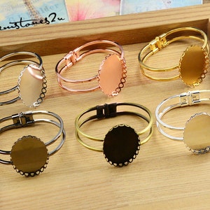 May include: Six different metal bangle bracelets with a round, scalloped bezel for a cameo or other embellishment. The bracelets are in silver, gold, rose gold, and black.