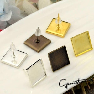 May include: Five different earring settings, each with a square-shaped base. The settings are made of silver, gold, and bronze. The settings are all the same size and have a post for attaching earrings.
