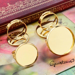 May include: Two gold adjustable ring blanks with round glass cabochon settings. The rings are open and adjustable to fit most finger sizes. The glass cabochons are clear and ready to be filled with resin, paint, or other embellishments.