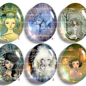Op de afbeelding: Zes ovale glazen cabochons met artistieke illustraties van figuren. Nummer 1 toont een persoon met een groen hoofddeksel, 2 toont twee figuren, 3 toont een persoon met wolven, 4 toont een bloemrijke scène, 5 toont een witharig figuur en 6 toont een persoon met oranje bloemen.