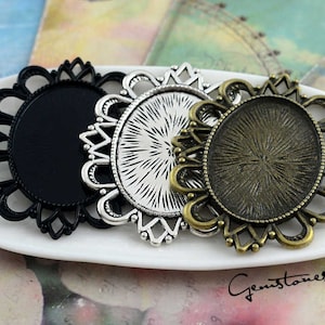 May include: Three ornate metal frames with a decorative floral design. The frames are silver, gold, and black. The frames are oval shaped and have a raised edge.