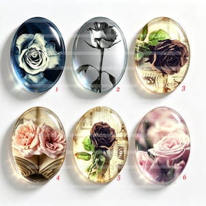 May include: Six oval glass cabochons featuring floral imagery. Number 1 shows a white rose on a dark background, 2 a black and white rose, 3 a dark rose over text, 4 two pink roses on an open book, 5 a dark rose over text, and 6 pink rose petals.