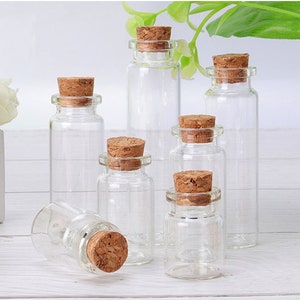 May include: Set of six clear glass bottles with cork stoppers. The bottles are various sizes and shapes.