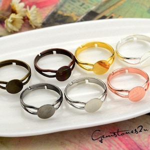 May include: Six adjustable ring blanks with a round bezel for setting cabochons. The ring blanks are made of metal and come in silver, gold, bronze, and rose gold.