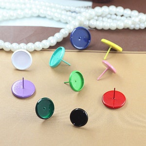 May include: Assortment of round, flat-backed cabochons with attached posts in various colors, including white, purple, green, blue, black, red, yellow, and pink.