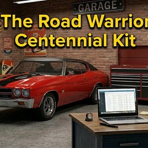 May include: A red muscle car with black racing stripes parked in a garage setting. The text The Road Warrior Centennial Kit is displayed prominently. A laptop, a notebook, and a pen sit on a wooden desk in the foreground, with a red tool chest.