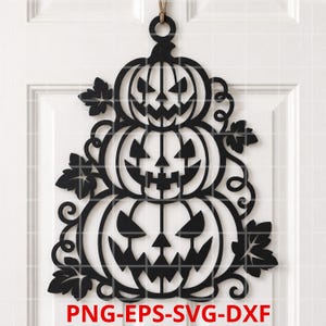 Könnte beinhalten: Ein schwarzer, lasergeschnittener Wandbehang mit einem vertikalen Stapel aus drei geschnitzten Kürbissen mit gezackten Gesichtern, umgeben von dekorativen Ranken und Blattsilhouetten, mit dem Text PNG-EPS-SVG-DXF am unteren Rand.
