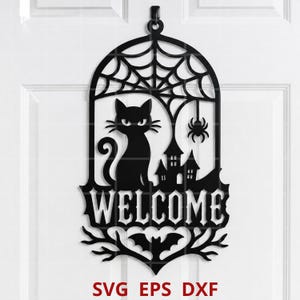 Puede incluir: Un colgante de pared negro cortado con láser que presenta la silueta de un gato, una telaraña, una araña, una casa embrujada y un murciélago. La palabra WELCOME está centrada. El texto SVG EPS DXF está impreso en rojo en la parte inferior.