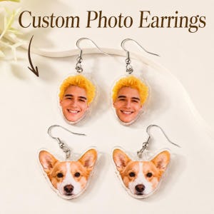 Könnte beinhalten: Zwei Paar personalisierte Foto-Ohrringe mit silberfarbenen Haken. Ein Paar zeigt eine Person mit leuchtend gelben Haaren, das andere Paar einen Corgi-Hund. Der Text Custom Photo Earrings ist oben im Bild aufgedruckt.
