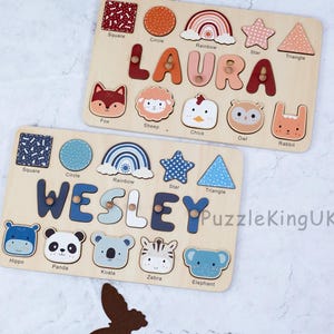 May include: Two wooden name puzzles featuring the names LAURA and WESLEY. Each puzzle includes cutouts for shapes like squares, circles, rainbows, stars, and triangles, alongside animal faces like foxes, sheep, chicks, owls, rabbits, hippos, pandas, koalas, zebras, and elephants.