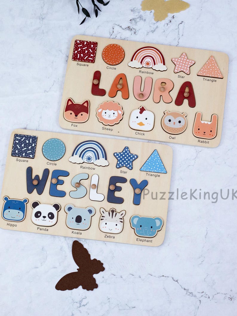 May include: Two wooden name puzzles featuring the names LAURA and WESLEY. Each puzzle includes cutouts for shapes like squares, circles, rainbows, stars, and triangles, alongside animal faces like foxes, sheep, chicks, owls, rabbits, hippos, pandas, koalas, zebras, and elephants.