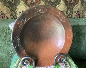 This vintage hand-thrown terracotta bowl features a burnished finish and an engraved fish motif along the wide rim