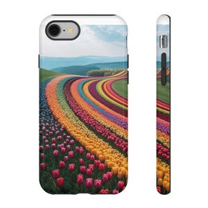 May include: A smartphone case featuring a vibrant, multi-colored landscape of curved tulip rows in shades of red, orange, yellow, purple, and pink. The design shows a rolling field under a blue sky with distant hills, visible from both back and side views.
