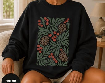 Könnte beinhalten: Ein schwarzes Sweatshirt mit Rundhalsausschnitt und einem zentralen Grafikdruck aus stilisiertem grünem Blattwerk, braunen Tannenzapfen und roten Beerenclustern, die in einem Rechteck auf der Vorderseite angeordnet sind.