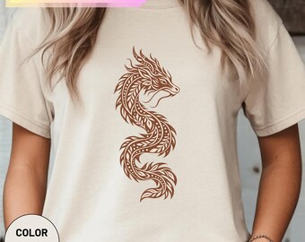 Könnte beinhalten: Ein naturfarbenes T-Shirt mit einer braunen Drachengrafik, die mit blattartigen Mustern verziert ist. Der Text BELLA CANVAS 3001 steht oben und ein kreisförmiges Etikett unten links trägt die Aufschrift COLOR NATURAL.