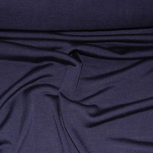 May include: A close-up of a dark blue fabric with a smooth, slightly textured surface. The fabric is folded and draped, showing its soft and drapey quality.