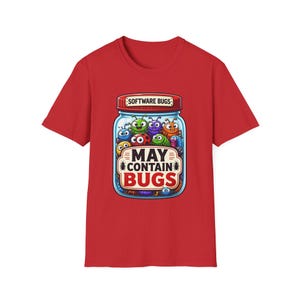 May include: A red short-sleeved t-shirt featuring a graphic of a glass jar filled with colourful cartoon insects. The jar lid is labelled "SOFTWARE BUGS" and the front of the jar displays the text "MAY CONTAIN BUGS" in bold lettering.