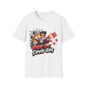Puede incluir: Una camiseta blanca de manga corta con un gráfico de un superhéroe con capa y máscara rojas, rodeado de iconos de documentos voladores etiquetados como W y PDF. Debajo del personaje, el texto dice PDF'ye Çevir Geç en letras rojas y blancas.