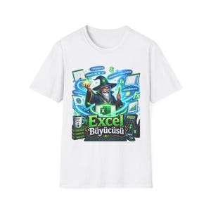 May include: A white short-sleeve t-shirt featuring a graphic of a wizard casting spells with Excel formulas, charts, and the text Excel Büyücüsü. The design includes a laptop, a calculator, a coffee mug, and floating mathematical symbols.