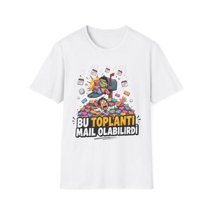 以下が含まれることがあります： 白い半袖Tシャツ。郵便受けから溢れ出る色とりどりの会議招待カードの山に埋もれた人物のグラフィックイラストが描かれています。グラフィックの下には「BU TOPLANTI MAIL OLABILIRDI」という太字のテキストがプリントされています。