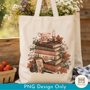 Puede incluir: Una bolsa de tela color crema con una ilustración impresa de una pila de libros antiguos, una taza de té, una vela encendida, unas gafas, un tintero, una pluma estilográfica y hojas de otoño. El diseño incluye detalles florales y hiedra.