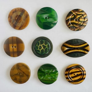 May include: Nine vintage buttons in various colors and patterns. The buttons include shades of brown, green, and yellow, with designs such as swirls, plaid, and geometric shapes. Each button has two or four holes for sewing.