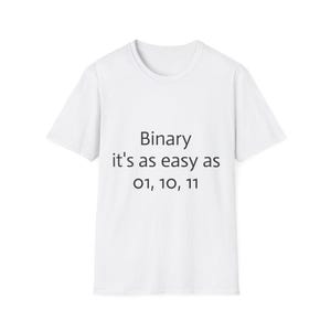 May include: A white short-sleeved t-shirt featuring black text printed on the front. The text reads: Binary it's as easy as 01, 10, 11. The garment has a standard crew neckline and a straight hemline, providing a clean and simple appearance.