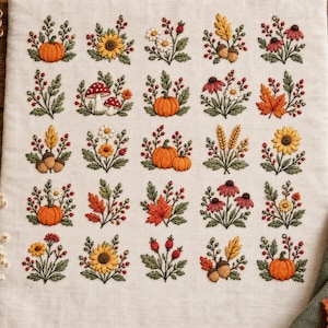 May include: A cream-colored fabric sampler featuring a grid of twenty-five individual embroidery designs. The motifs include orange pumpkins, yellow sunflowers, red mushrooms, brown acorns, autumn leaves, wheat stalks, and various small wildflowers.
