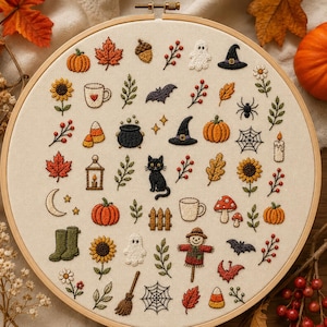 Può includere: Un telaio da ricamo rotondo in legno contenente un tessuto color crema con varie icone autunnali e di Halloween ricamate, tra cui zucche, un gatto nero, uno spaventapasseri, fantasmi, pipistrelli, girasoli, funghi, foglie e ragnatele.