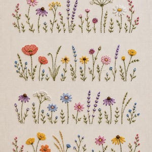 Op de afbeelding: Een borduurwerk op lichtbeige stof met vier horizontale rijen van diverse wilde bloemen. Het ontwerp bevat gedetailleerd gestikte stengels, bladeren en bloesems in tinten roze, geel, paars, blauw, oranje en wit.