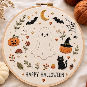 Könnte beinhalten: Ein runder Holzstickrahmen mit weißem Stoff, der handgestickte Halloween-Motive wie ein zentrales Gespenst, eine schwarze Katze, Kürbisse, Fledermäuse, einen Halbmond, ein Spinnennetz und den Schriftzug "HAPPY HALLOWEEN" in schwarzem Garn zeigt.