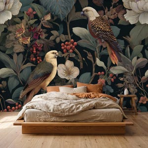 May include: A low-profile wooden bed frame with a beige duvet and pillows sits against a dark wallpaper featuring large white flowers, green foliage, red berries, and two birds with cream-coloured heads and brown, orange, and black patterned wings.
