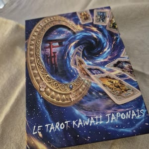 Peut inclure: Une boîte de jeu de tarot rectangulaire avec un fond représentant un vortex cosmique bleu et violet. Le design inclut un cadre circulaire doré, un portail torii rouge et plusieurs cartes de tarot flottantes. Le texte LE TAROT KAWAII JAPONAIS est imprimé en blanc en bas.