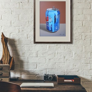 Puede incluir: Una pintura enmarcada de una lata de Pepsi azul y roja con pintura azul goteando por el lado. La lata est&aacute; sobre una superficie gris con un fondo marr&oacute;n.