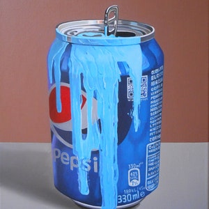Puede incluir: Una lata de Pepsi azul y roja con un l&iacute;quido azul goteando por el lado. La lata es de 330 ml y tiene una pesta&ntilde;a de apertura. La lata est&aacute; sobre una superficie blanca.