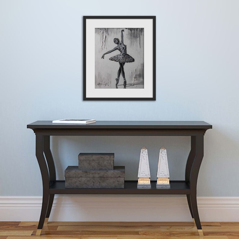 May include: A black and white framed print of a ballerina in a tutu, with a gray background.