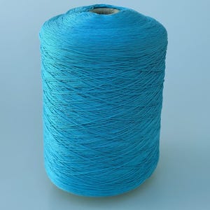 May include: A large cylindrical spool of vibrant turquoise blue yarn. The thread is tightly wound in a cross-hatch pattern around a central cardboard core, creating a textured surface with a consistent, bright color throughout the entire object.