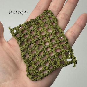 May include: A square swatch of olive green yarn featuring an open, net-like crochet stitch pattern. The text Held Triple is printed in black in the upper left corner of the image, indicating the yarn weight and technique used for this piece.