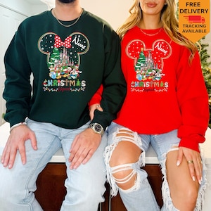 May include: A dark green sweatshirt and a red sweatshirt, each featuring a graphic of a Mickey Mouse silhouette filled with a Christmas castle, characters, and the text "Name" and "CHRISTMAS Squad" with colorful holiday lights and snowflakes.