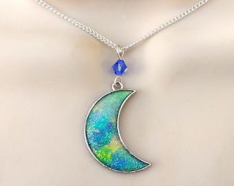 Crescent moon necklace in pastel watercolors sparkling blue, yellow, turquoise, and green