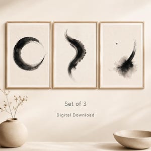 Puede incluir: Un conjunto de tres l&aacute;minas de arte enmarcadas con pinceladas de tinta negra sobre un fondo beige claro. La primera l&aacute;mina muestra una forma circular, la segunda una l&iacute;nea curva y la tercera una mancha con un punto. Texto: Set of 3 Digital Download.