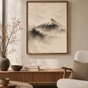 K&ouml;nnte beinhalten: Ein gerahmter Wandkunstdruck mit einer Illustration im monochromen Tusche-Stil, die einen schneebedeckten Berggipfel &uuml;ber den Wolken zeigt. Das Kunstwerk ist in der oberen rechten Ecke mit Digital Download beschriftet und stellt eine Landschaft dar.