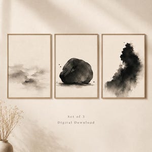 May include: A set of three framed wall art prints featuring black ink wash paintings on a beige background. The left print shows soft clouds, the centre print depicts a solid rock, and the right print displays an abstract ink splash. Text reads Set of 3 Digital Download.