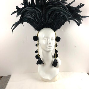 May include: Black feather headdress with black pom-poms and gold chains hanging down the sides.