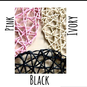 May include: Three heart-shaped woven wicker decorations in pink, ivory, and black.