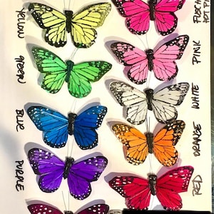 Puede incluir: Colecci&oacute;n de decoraciones de mariposas coloridas en varios tonos, incluyendo amarillo, verde, azul, morado, ciruela, rosa, blanco, naranja y rojo. Cada mariposa tiene un cuerpo negro y alas delicadas, ideal para manualidades o decoraci&oacute;n.