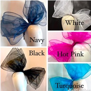 May include: Five large tulle bows in different colors: navy, white, hot pink, black, and turquoise. The bows are arranged in a grid pattern on a white background.