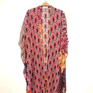 May include: A pink, orange, and brown patterned kimono with a geometric design. The kimono has a V-neck and short sleeves.