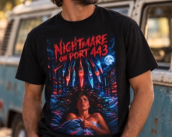 May include: A black short-sleeve t-shirt featuring a graphic print with the text "NIGHTMARE ON PORT 443". The design depicts a person in bed beneath glowing, sharp, red and blue hanging objects, with a full moon in the night sky.