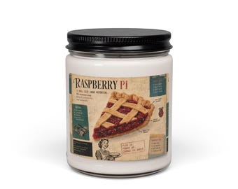 May include: A white candle in a clear glass jar with a black lid. The label features a vintage-style illustration of a raspberry pie slice, the text Raspberry Pi, and technical diagrams. The design includes a small illustration of a person.